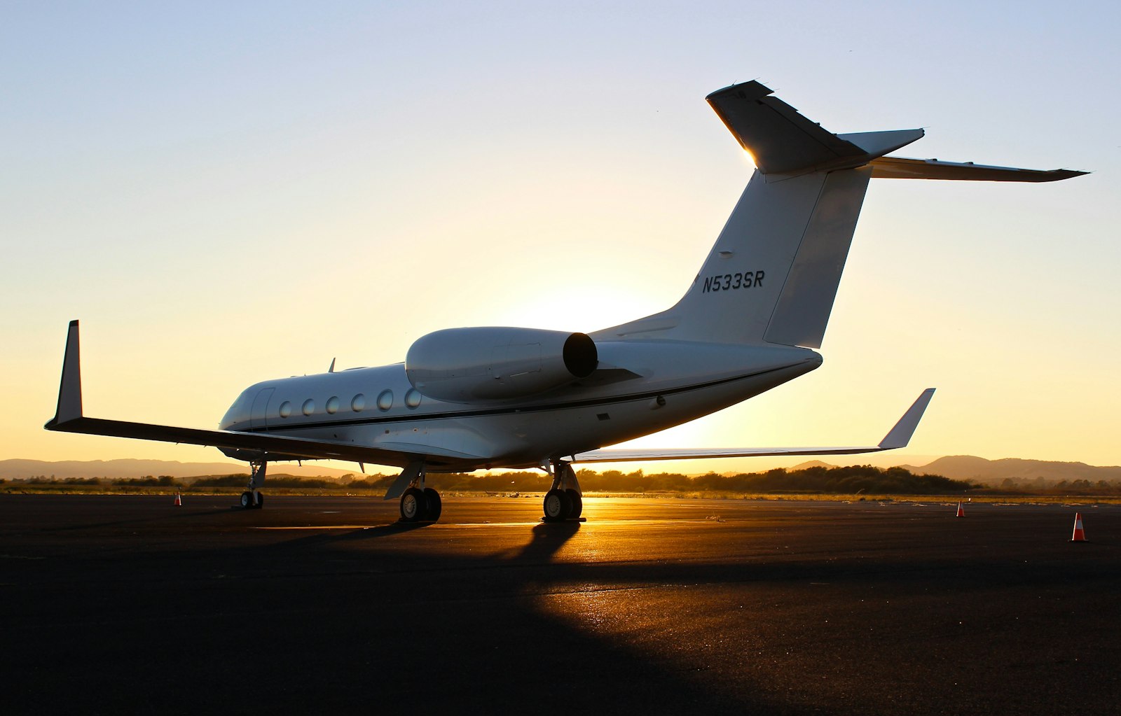 Private jet silhouetted on the tarmac at dusk
