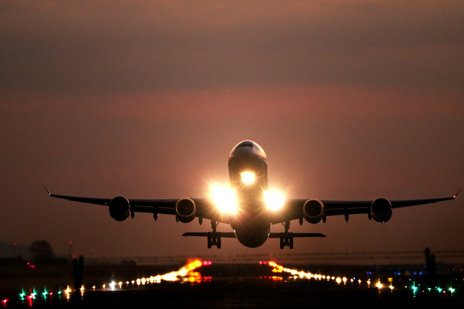 Aircraft lifting off a lit runway at night