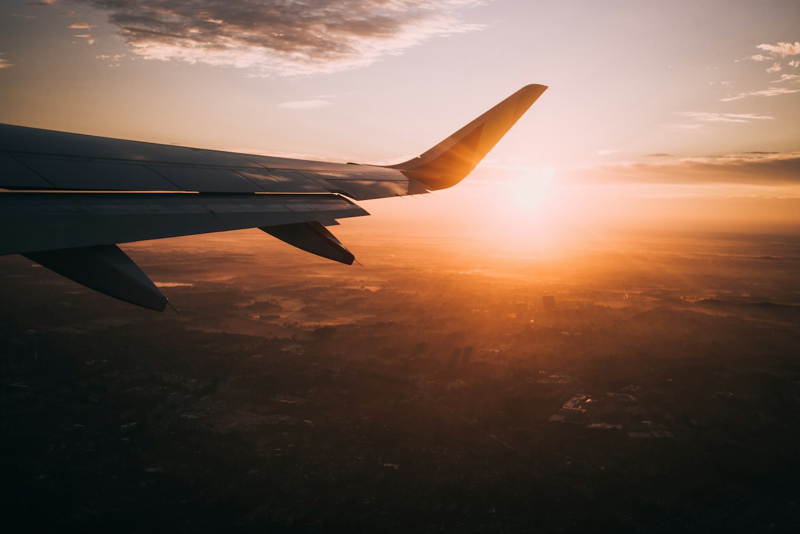 Wing over a gold horizon at cruise altitude
